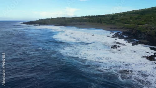 Play of waves on a black sand beach at Reunion Island