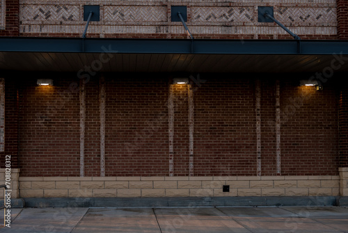 A modern brick wall gracefully illuminated at sunset, with a centralized light casting a warm glow.
