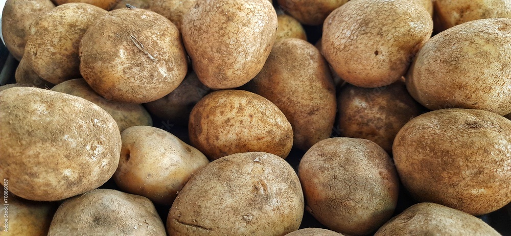 Close up of heap raw potatoes placed on stall of market ready to sold. Potato background Close up of heap raw potatoes placed on stall of market ready to sold. Potato background