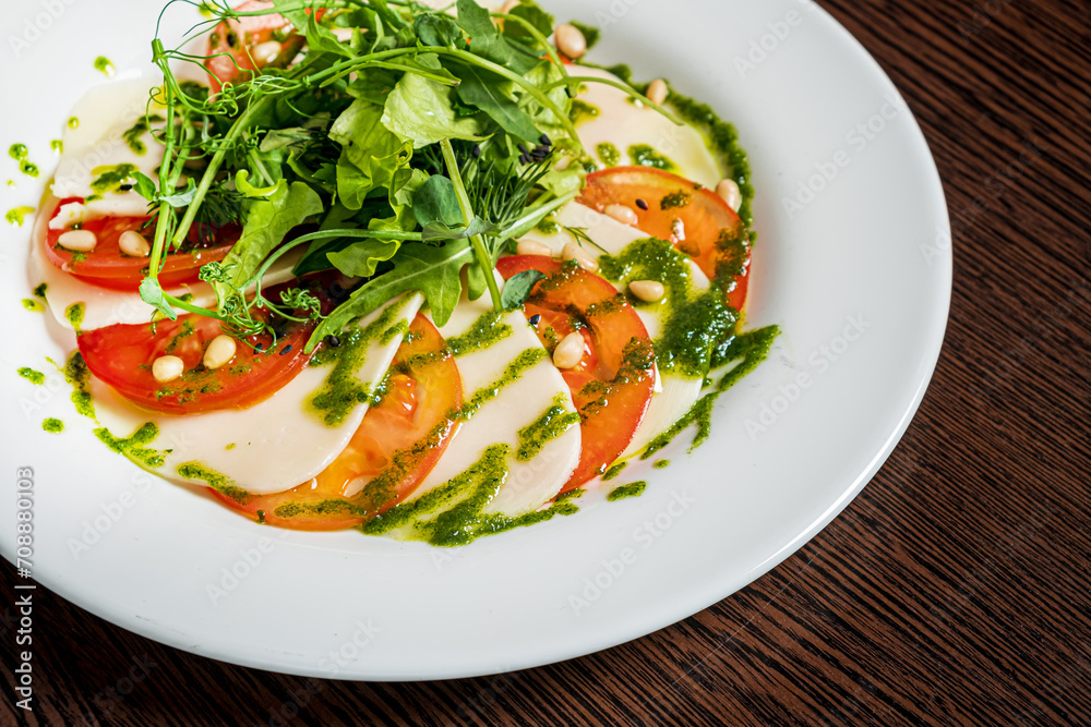 Caprese salad with mozzarella cheese, tomatoes and arugula Caprese salad with mozzarella cheese, tomatoes and arugula