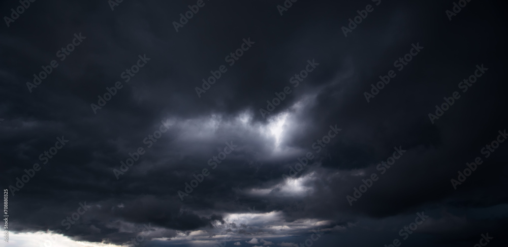 The dark sky with heavy clouds converging and a violent storm before the rain.Bad or moody weather sky and environment. carbon dioxide emissions, greenhouse effect, global warming, climate change.