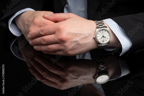 Hands of a business woman on a black reflective table