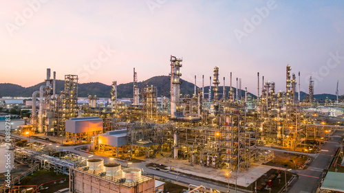 Oil and gas industrial refinery at twilight, Oil refinery and Petrochemical plant pipeline steel, Refinery factory oil storage tank and pipeline steel at night.