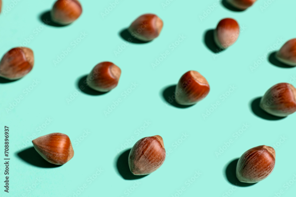Shelled hazelnuts on blue background, closeup