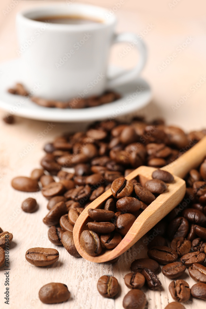 Scoop and coffee beans on light wooden background Scoop and coffee beans on light wooden background