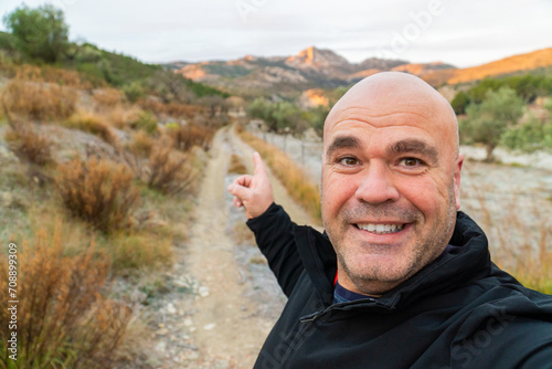 Cheerful hiker takes a selfie enjoying nature and mountains