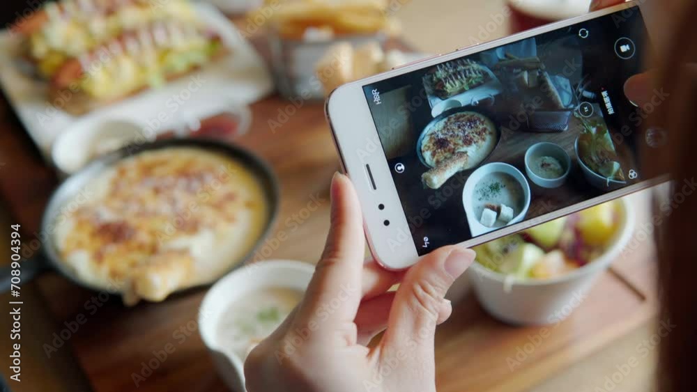 Take a photo of a smartphone for lunch or dinner. Woman taking picture with phone. Posting or sharing popular food for social media. Take a photo of a smartphone for lunch or dinner. Woman taking picture with phone. Posting or sharing popular food for social media.