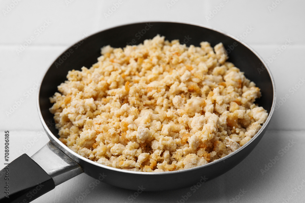 Fried ground meat in frying pan on white tiled table, closeup Fried ground meat in frying pan on white tiled table, closeup
