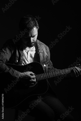 Fotografie Black and white portrait of a caucasian man playing an acoustic guitar