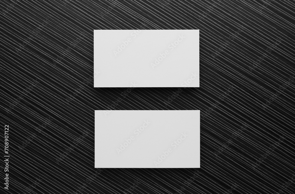 Blank business cards on black wooden table, flat lay. Mockup for design