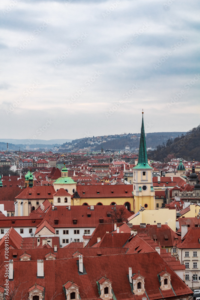 Panoramic view of the medieval city Prague during winter with a church and mountains in the background