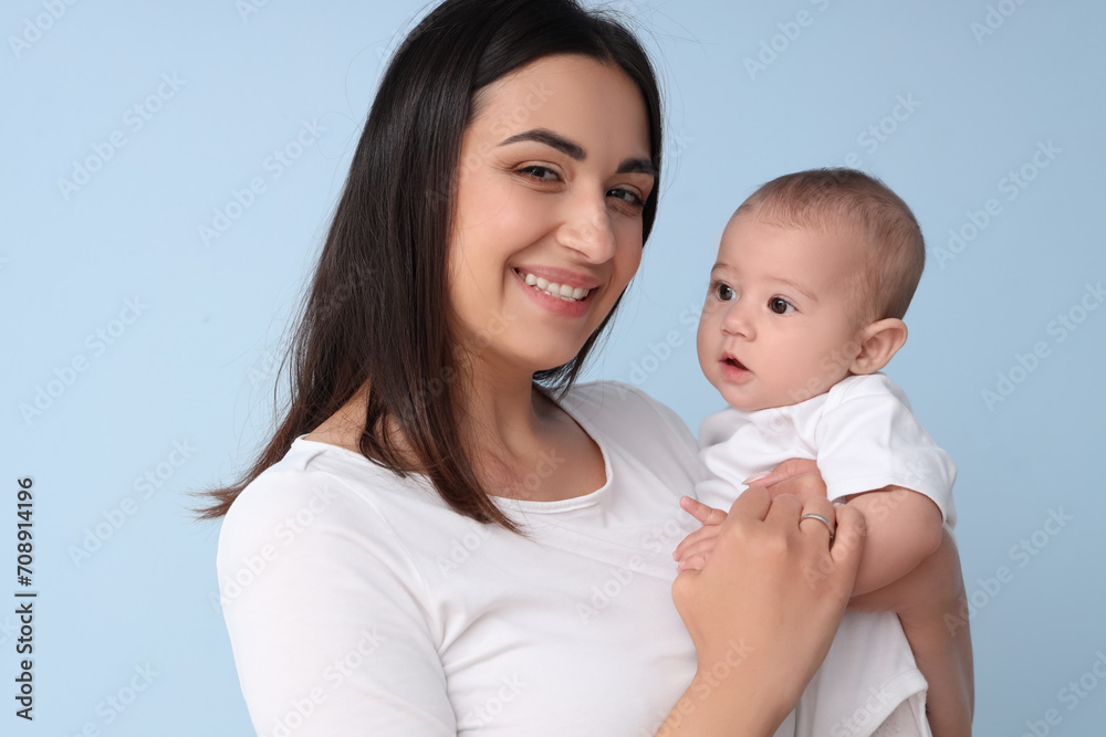 Happy mother with her little baby on blue background, closeup Happy mother with her little baby on blue background, closeup