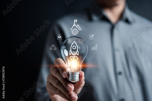 Rocket launch idea inside lightbulb. strategically planning and initiating a corporate startup. aim to achieve objectives through value development, fostering leadership.