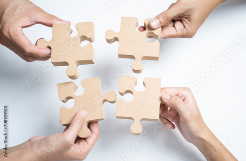 Asian group of business people holding a jigsaw puzzle pieces.