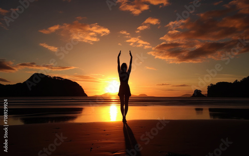 yoga enthusiast practicing poses on the beach in sunset