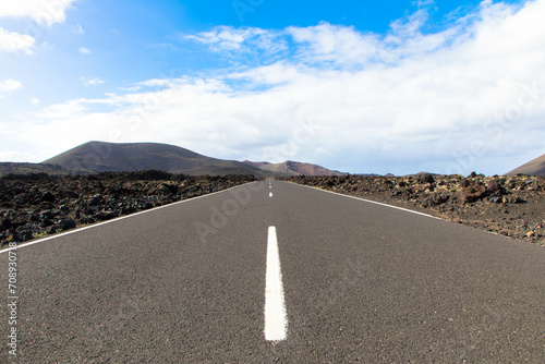 Panoramic view of empty asphalt road LZ-67 in volcanic landscape of Timanfaya National Park, Lanzarote, Canary Islands, Spain, Europe