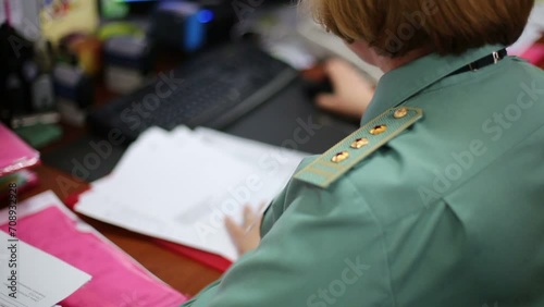Female customs officer in uniform works at workplace photo