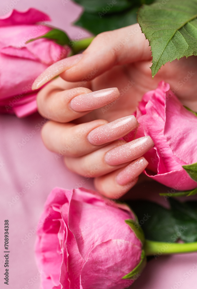 Female hands with pink nail design hold pink roses Female hands with pink nail design hold pink roses