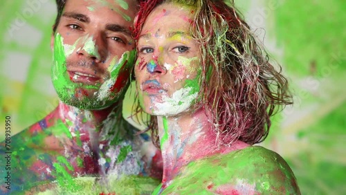 Faces of painted young man and woman who rub cheeks. photo