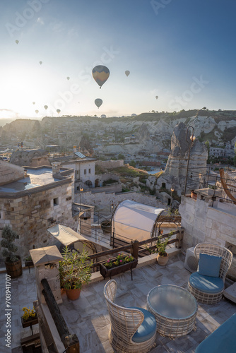 View of the city of Goreme with caves and hot air balloons in Cappadocia during sunrise. Fabulous landscapes of the mountains of Cappadocia Goreme, Türkiye