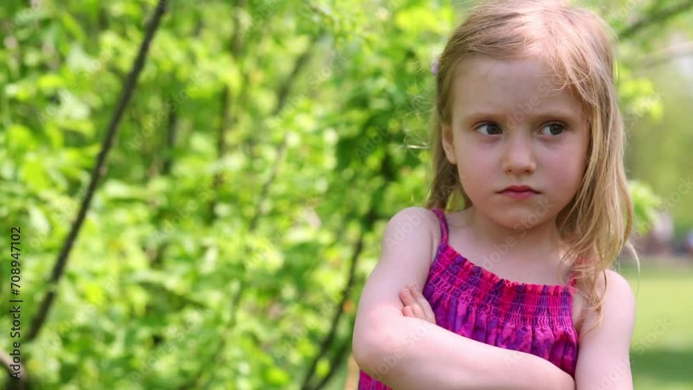 Sullen little girl stands with her arms crossed on the chest Sullen little girl stands with her arms crossed on the chest