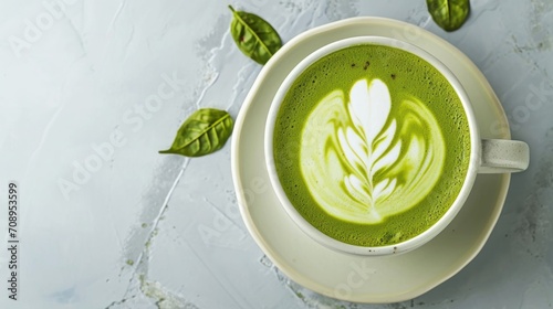 A ceramic cup with matcha latte with a delicate white leaf pattern on the frothy surface, space for text