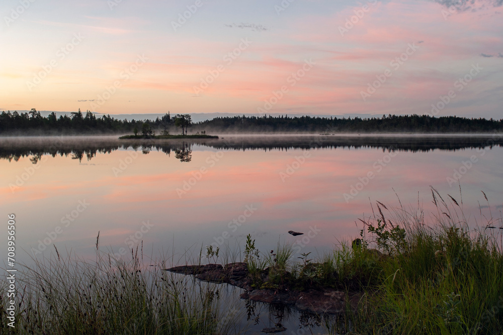 Pastel colors of the night sky reflected on the still surface of a small lake Pastel colors of the night sky reflected on the still surface of a small lake