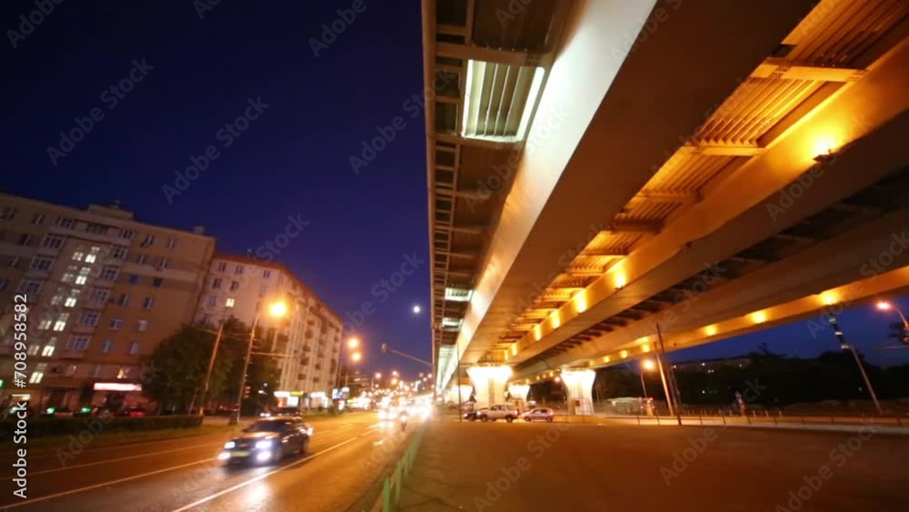 Many cars move at road near overpass at night in Moscow, Russia