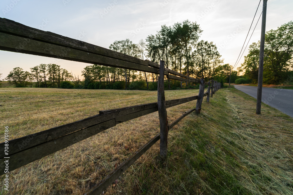 An old wooden rickety fence for grazing animals in a field.