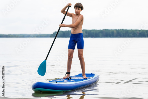 Teenager and SUP board. Active recreation on the Senftenberg lake. Federal land of Brandenburg. Germany.