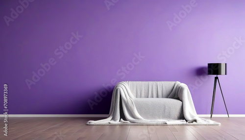 Sofa and pouf covered with blanket against purple wall with copy space. Minimalist interior design of modern living room.