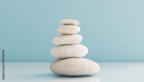 white sea pebble stone stack on light blue background