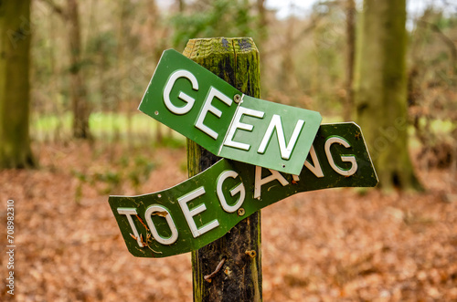 Oostvoorne, The Netherlands, December 23, 2023: twisted and distorted sign in a forest with the words "no entry" in Dutch