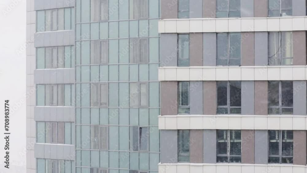 Building with many windows during snowfall at dull winter day Building with many windows during snowfall at dull winter day