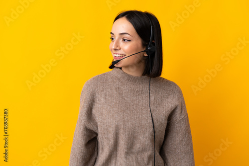 фотографія Young telemarketer woman isolated on yellow background looking to the side and s