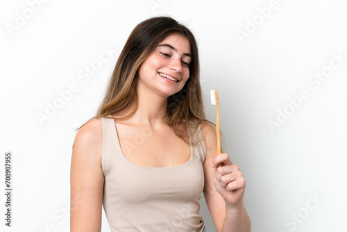 Young caucasian woman brushing teeth isolated on white background with happy expression