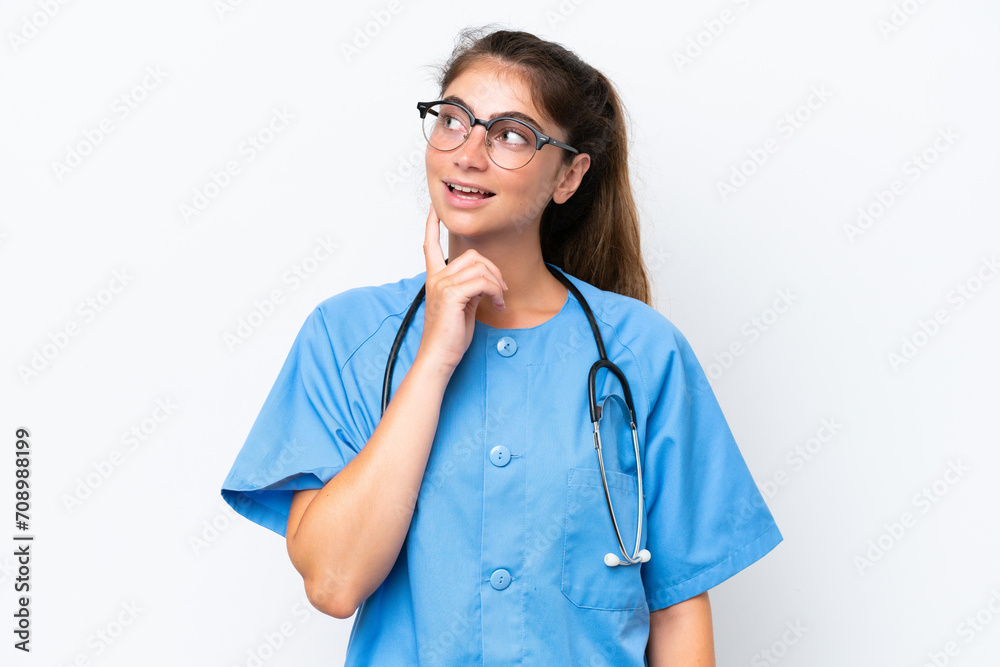 Young nurse doctor woman isolated on white background thinking an idea while looking up Young nurse doctor woman isolated on white background thinking an idea while looking up
