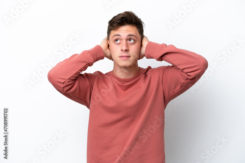 Young handsome Brazilian man isolated on white background frustrated and covering ears © luismolinero