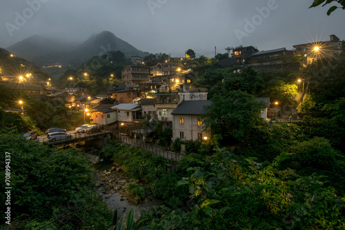Night view of old street with stream and yellow lights at new taipei city