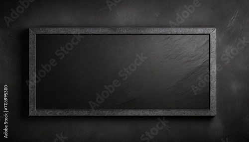black on black empty black granite stone rectangle board on black textured cement background top view vith copy space for your text photo