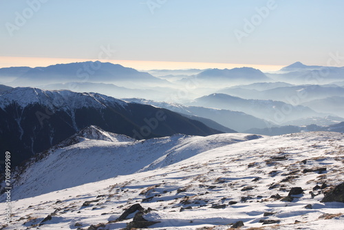 A breathtaking panorama of snow-capped peaks stretching as far as the eye can see, invoking a sense of serenity.