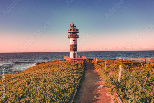 Lonely lighthouse in sunset on the coast of Galicia, Spain. Island of Pancha (Isla Pancha) clote to Ribadeo village photo