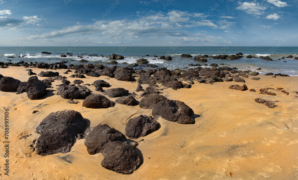West Africa, Senegal. The sandy beach of the resort area is surrounded by rocks and fragments of rocks of volcanic origin. West Africa, Senegal. The sandy beach of the resort area is surrounded by rocks and fragments of rocks of volcanic origin.