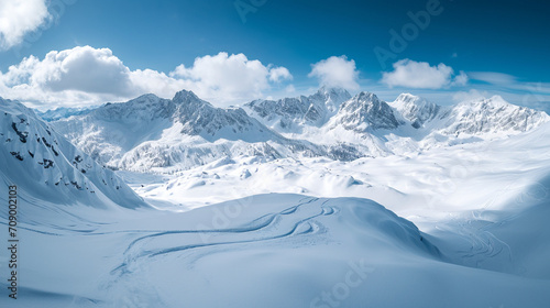 Stunning panoramic view of snowy mountain range. The untouched powder snow with ski tracks crisscrossing. Bright and crisp winter day with snow capped peaks and clear blue sky. Cold adventure and expe © Moritz