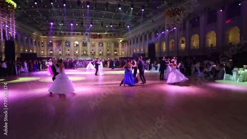 Couples dance under purple lights at 11th Viennese Ball photo