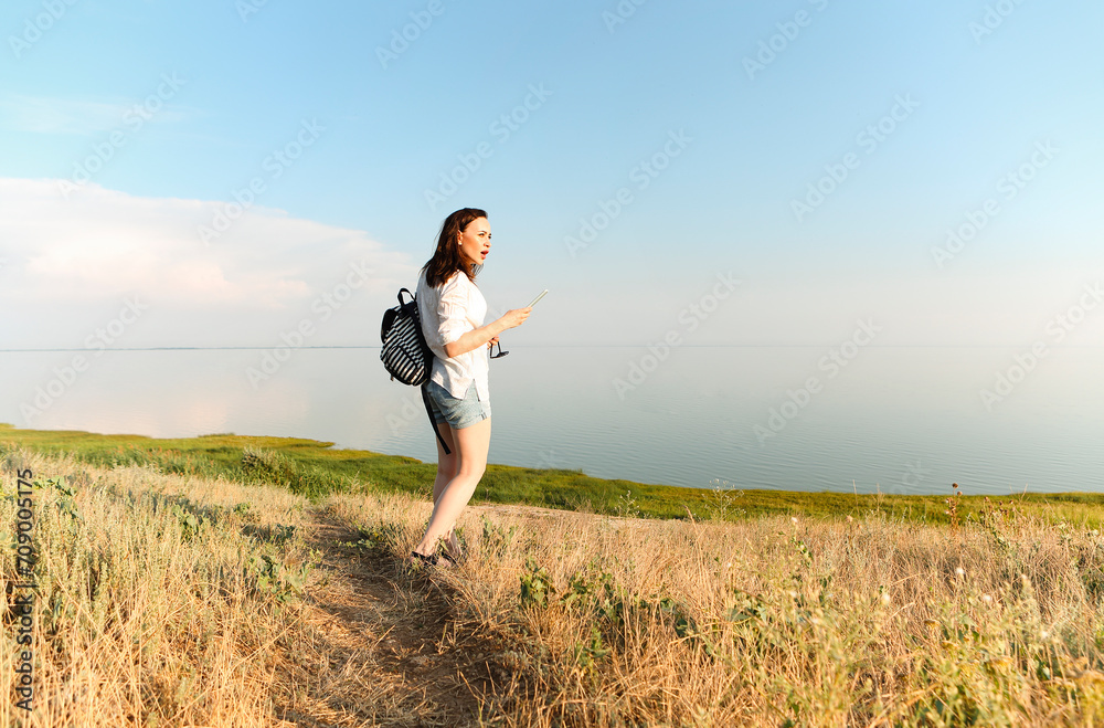 Side view of carefree female standing near sea and at sundown Side view of carefree female standing near sea and at sundown