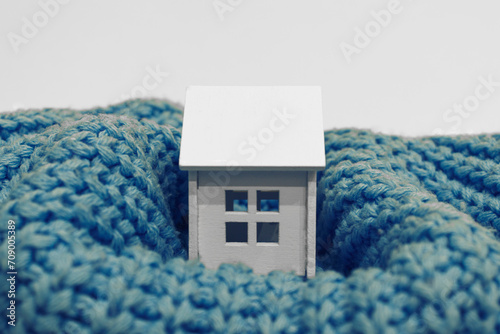 house in winter, heat preservation, Little house in a knitted sweater. The concept of comfort in the home, home insulation.