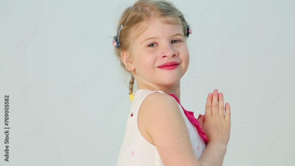 Little smiling girl folds her arms in front of herself and turns Little smiling girl folds her arms in front of herself and turns