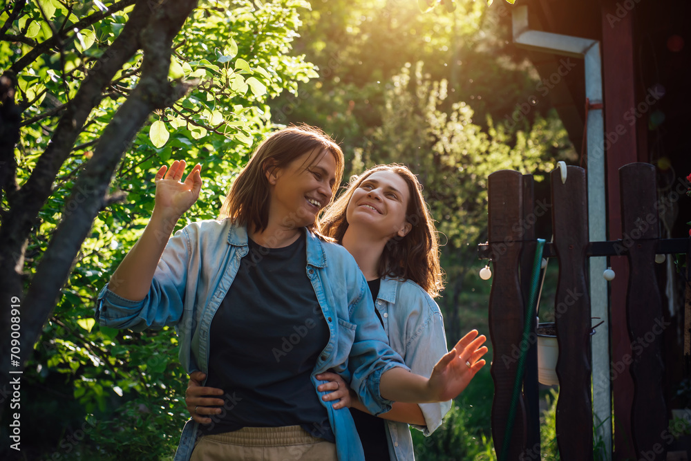 Two happy laughing lesbian women are having fun in a green garden in the rays of the bright sun. Happy LGBT family life Two happy laughing lesbian women are having fun in a green garden in the rays of the bright sun. Happy LGBT family life