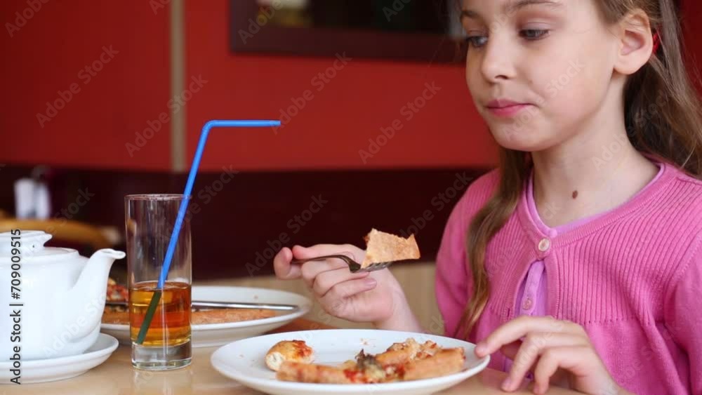 Happy girl in pink wear eats appetizing pizza in pizzeria Happy girl in pink wear eats appetizing pizza in pizzeria